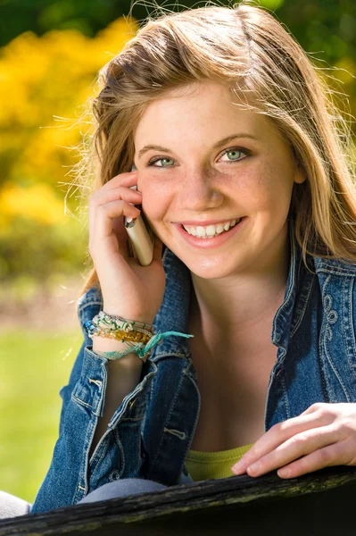 Joyful adolescent girl using her mobile phone — Stock Photo, Image