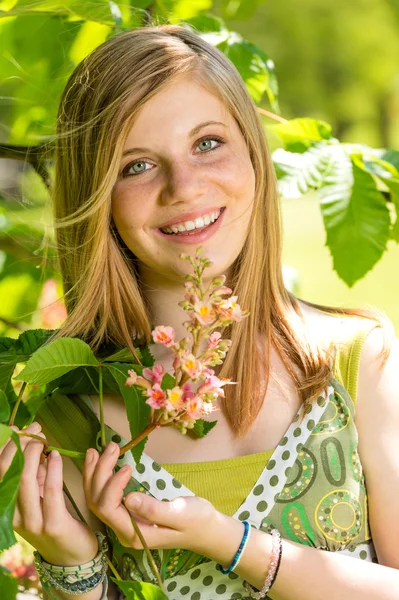 Adolescente chica oliendo el árbol floreciente en primavera —  Fotos de Stock