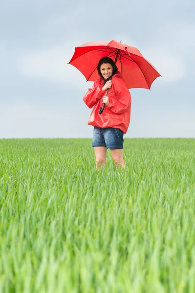 Возбужденная девочка-подросток с красным зонтом — стоковое фото