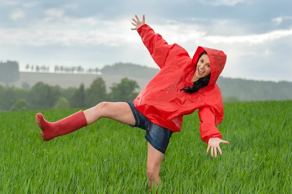 Speelse tienermeisje dansen in de regen Stockfoto