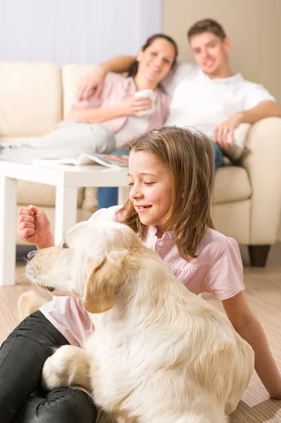 Játékos lány petting családi kutya a szülőkkel — Stock Fotó