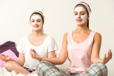 Beyaz yüz maskesi giyen kadın meditasyon