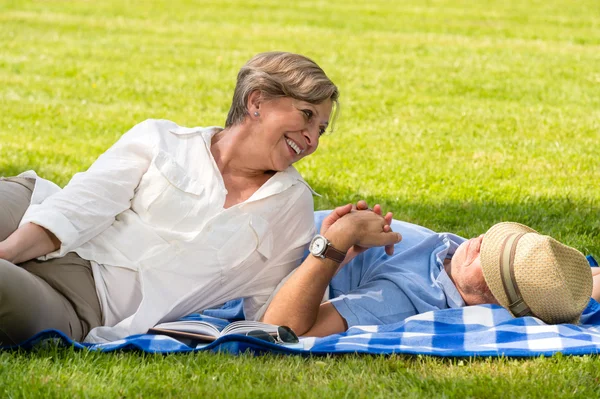 Bejaarde echtpaar genieten van ontspannen tijd in park — Stockfoto