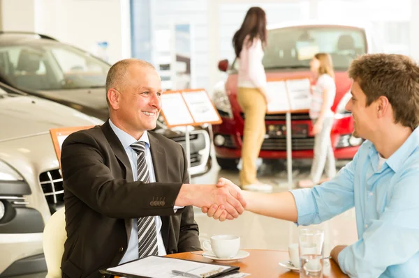 Customer and car salesman shaking hands — Stock Photo, Image