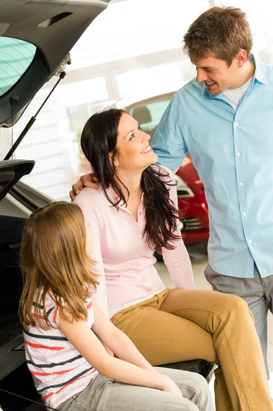 Happy family sitting in new car 's boot — стоковое фото