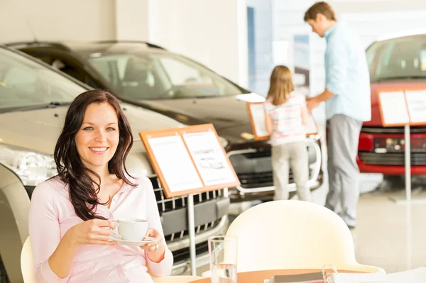 Customer drinking coffee in car dealership — Stock Photo, Image