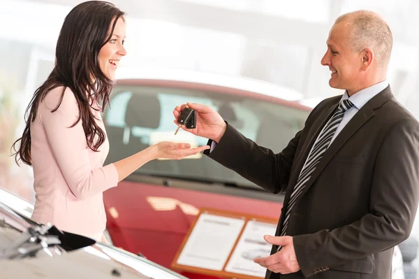 Salesman handing car keys to woman — Stock Photo, Image