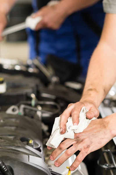 Mecánico de coche limpiándose las manos sucias — Foto de Stock