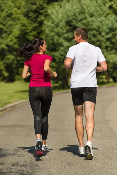 Rear view of couple friends jogging together — Stock Photo, Image