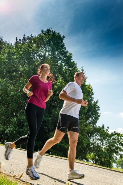 Ungt par jogging i en park — Stockfoto