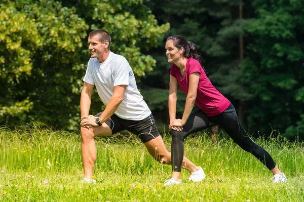 Kadın ve erkek atlet açık havada germe — Stok fotoğraf