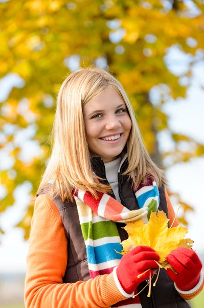 Glimlachend blonde tiener meisje herfst bos verlaat — Stockfoto