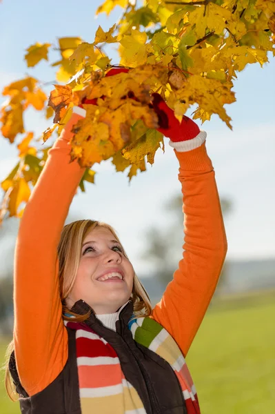 Sorrindo menina escolhendo folhas secas árvore de outono — Fotografia de Stock
