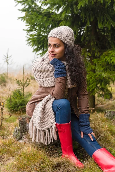 Poserar hösten kvinna sitter i furu skog — Stockfoto