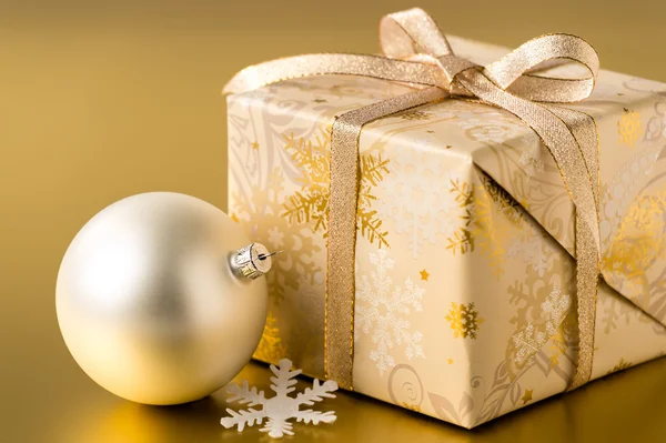 Regalo di Natale e bauble su sfondo oro — Foto Stock