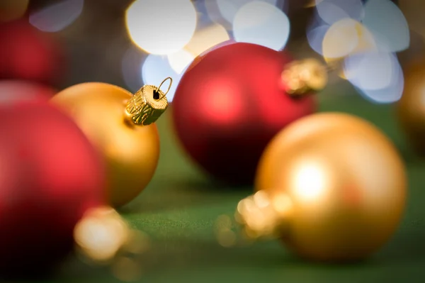 Золотые и красные рождественские безделушки на зеленом — стоковое фото