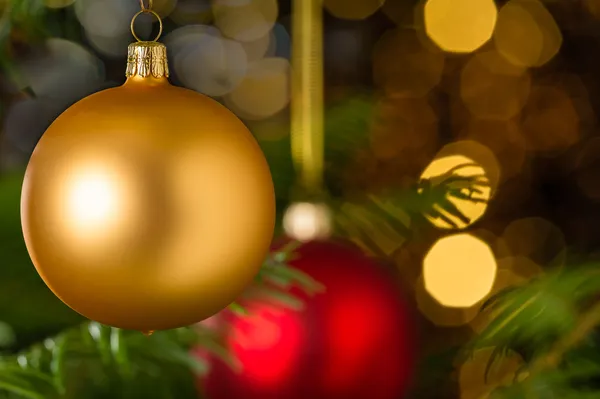 Guld jul boll hängande på xmas tree — Stockfoto