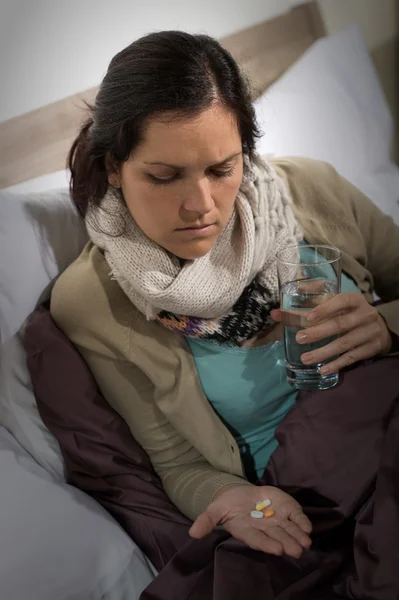 Sick woman looking at medicine pills — Stock Photo, Image