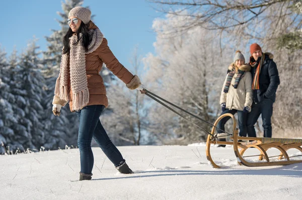 Jonge vrouw trekken winter slee sneeuw platteland — Stockfoto