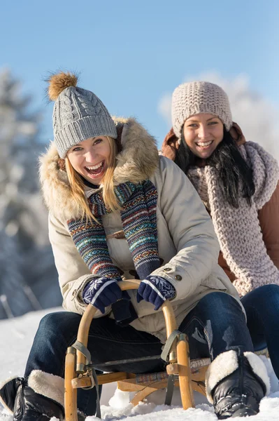 Two female friends sledge downhill in wintertime — Stock Photo, Image