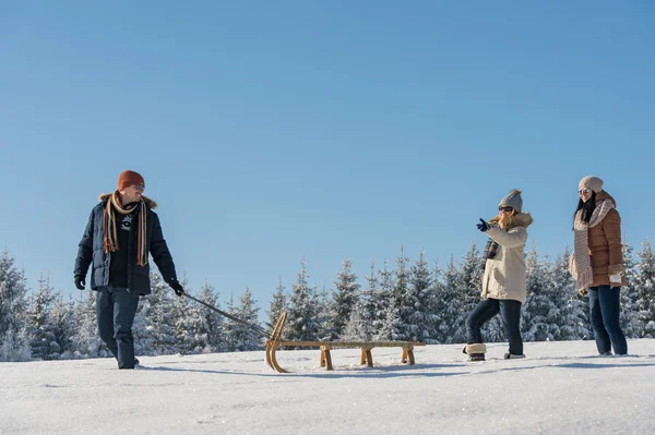 Jonge man trekken van sneeuw slee winter landschap — Stockfoto