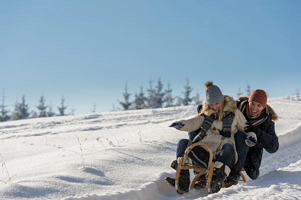 Joven pareja juguetona divirtiéndose en la nieve — Foto de Stock