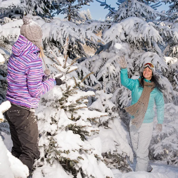 Two girlfriends throw snow balls winter forest — Stock Photo, Image