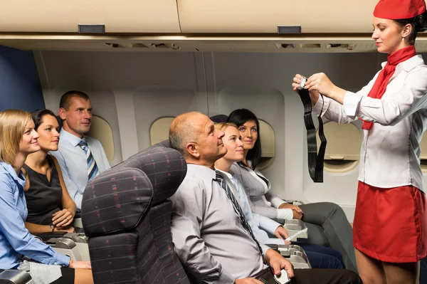 Flight attendant demo fastening seat belt airplane — Stock Photo, Image