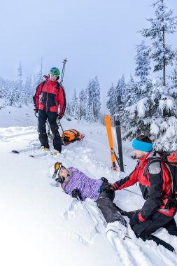 Ski patrol helping woman with broken leg clipart