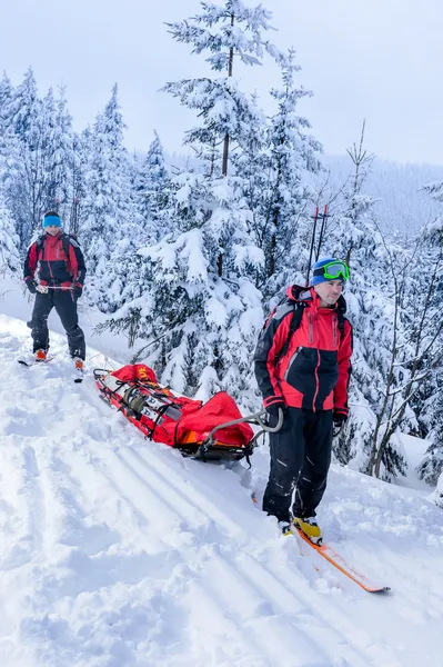 Ski patrol transporting injured skier snow forest — Stock Photo, Image