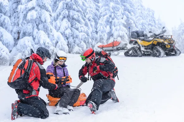 Equipa de patrulha de esqui resgate mulher braço quebrado — Fotografia de Stock