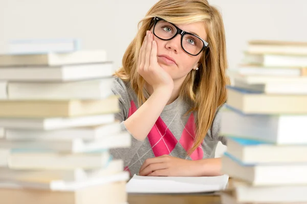 Étudiante ennuyée entre pile de livres — Photo