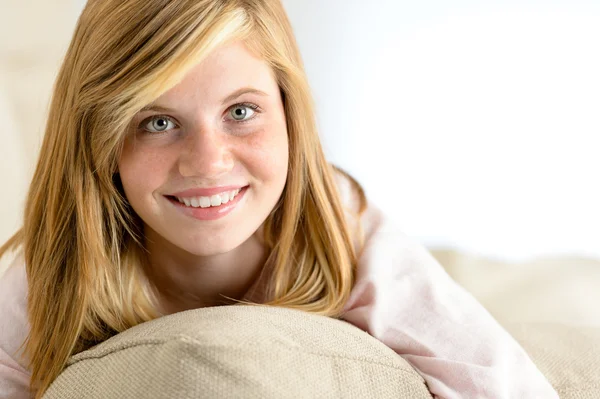 Smiling beautiful teenager girl lying on pillow — Stock Photo, Image