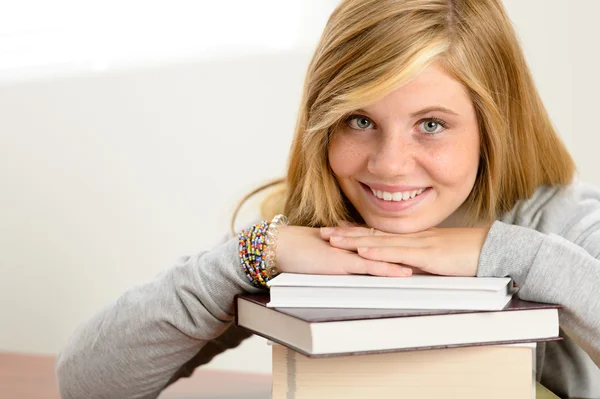 Estudante sorridente adolescente inclinado cabeça em livros Fotografias De Stock Royalty-Free