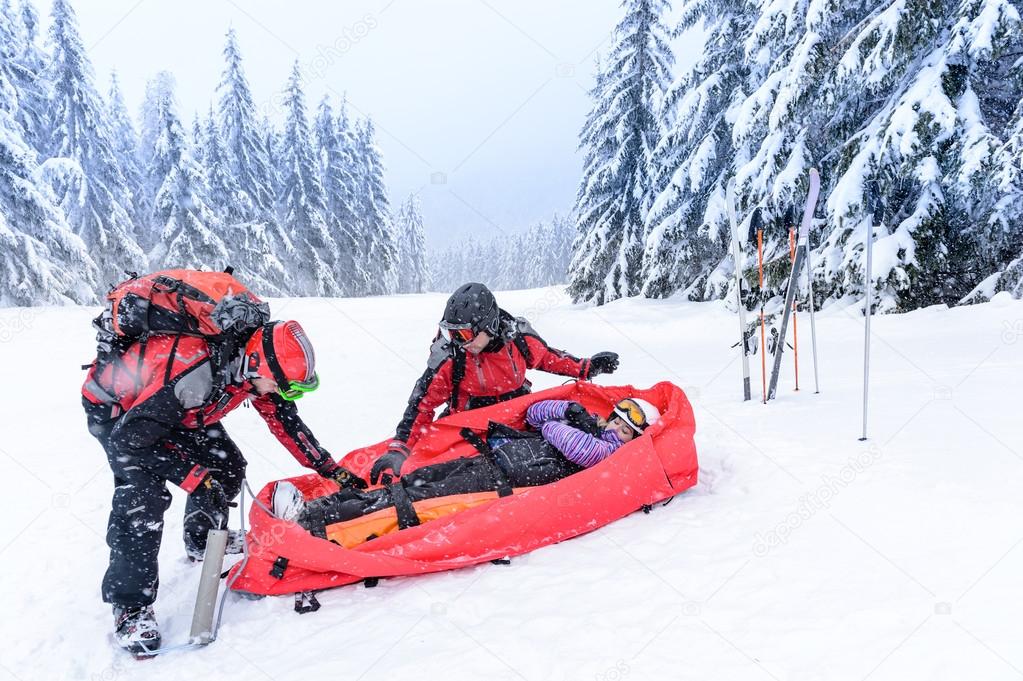 Ski patrol with rescue sled injured woman