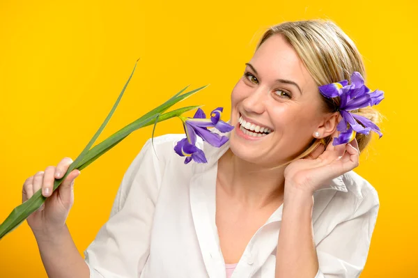 Усміхнена жінка з весняною квіткою у волоссі — стокове фото