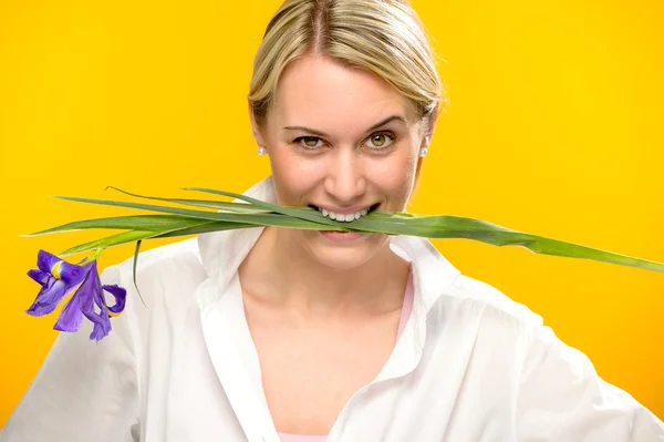 Mulher mordida primavera íris flor entre os dentes — Fotografia de Stock