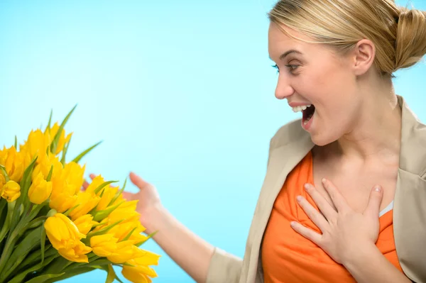 Mulher surpresa recebe buquê de tulipas amarelas — Fotografia de Stock