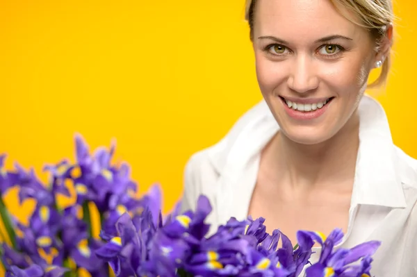Leende kvinna med våren lila iris Stockbild