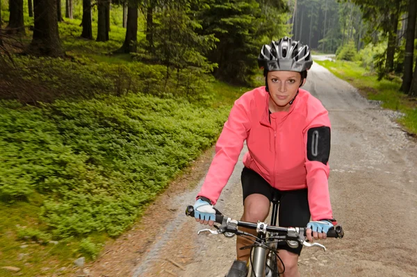 Kvinna mountainbike genom skogsväg — Stockfoto