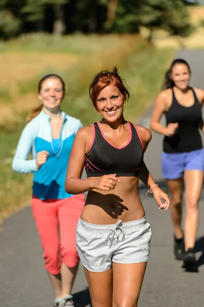 Amigos corriendo juntos al aire libre sendero soleado — Foto de Stock