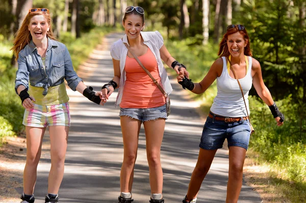 Vrolijke jonge vrouwen op rolschaatsen buiten — Stockfoto