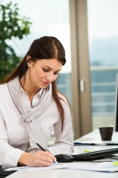 Affärskvinna skriver i office — Stockfoto