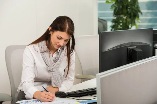 Geschäftsfrau schreibt am Schreibtisch — Stockfoto
