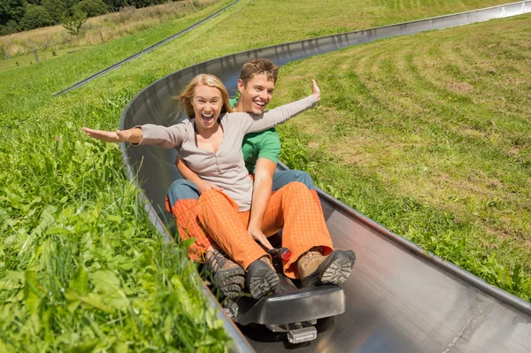 Casal desfrutando Alpine Coaster Luge — Fotografia de Stock