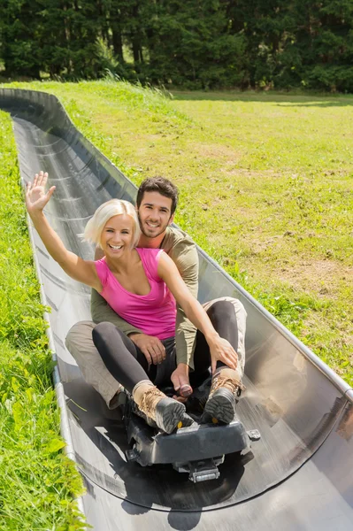 Couple heureux jouissant du traîneau d'été — Photo