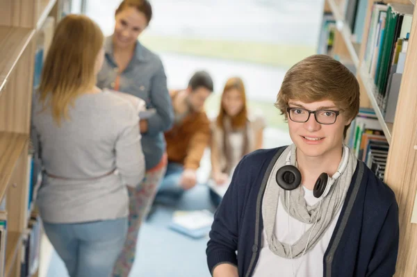 Student met koptelefoon in bibliotheek — Stockfoto
