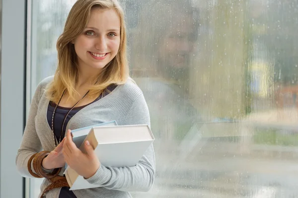 Student met boeken in de voorkant van venster — Stockfoto