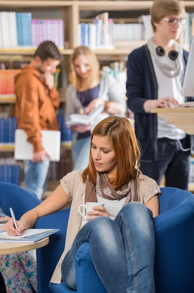 Écrire des notes à la bibliothèque — Photo