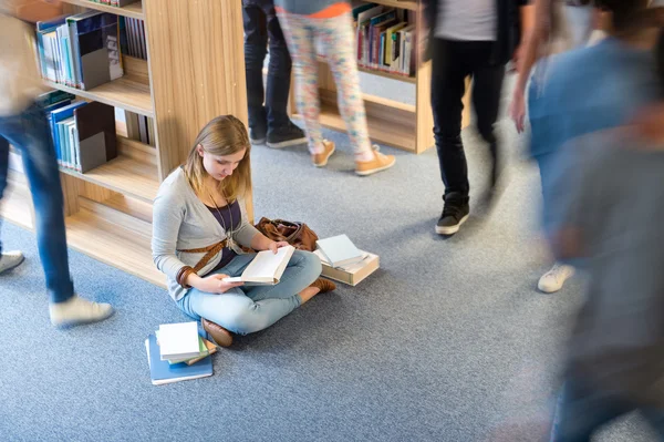 Studente seduto piano in biblioteca movimento sfocatura — Foto Stock